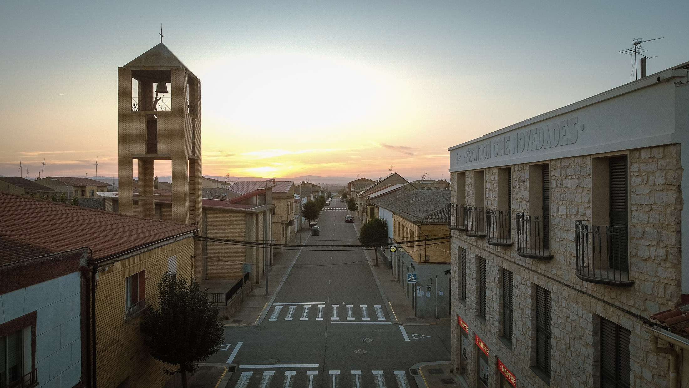 Perspectiva de la calle con la torre de la iglesia al fondo y el lateral del edificio Mapfre a la derecha